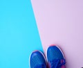 Pair of sports sneakers with blue laces on a colored abstract background Royalty Free Stock Photo
