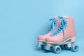 Pair of stylish quad roller skates on color background.