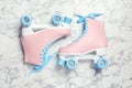 Pair of stylish quad roller skates on marble background