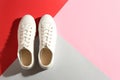 Pair of stylish sneakers on color background, top view