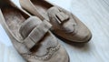 a pair of suede woman shoe in cream color which is very dusty and dirty