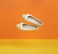 A pair of summer flying yellow shoes on a yellow-orange background for a banner Royalty Free Stock Photo