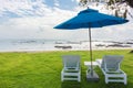 Pair of sun loungers and a beach umbrella on a deserted beach, Perfect vacation concept