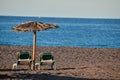 Pair of sun loungers and an umbrella on a deserted beach in the Canary Islands in Spain