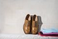 Pair of Tanned Brogue Derby Shoes of Calf Leather with Rubber Sole With Heap of Clothes On Coach Royalty Free Stock Photo