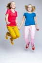 Pair of Teenager Twins Having Fun and Jumping Together Indoors