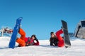 Pair with their snowboards lying in snow on ski slope Royalty Free Stock Photo