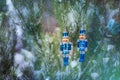 A pair of tin solders hanging on a snowy fir tree in the forest. Christmas toys Royalty Free Stock Photo