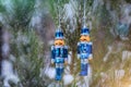 A pair of tin solders hanging on a snowy fir tree in the forest. Christmas toys Royalty Free Stock Photo