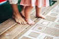 A pair of toddler`s feet and a pair of adult feet, the first steps of a child, caring for relatives