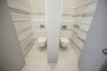 A pair of toilet cubicles in an office building made in marble and wood,top viev.