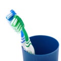 Pair of toothbrushes in blue plastic cup isolated over white background Royalty Free Stock Photo