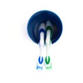 Pair of toothbrushes in blue plastic cup isolated over white background Royalty Free Stock Photo