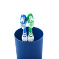 Pair of toothbrushes in blue plastic cup isolated over white background Royalty Free Stock Photo