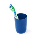 Pair of toothbrushes in blue plastic cup isolated over white background Royalty Free Stock Photo