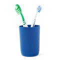 Pair of toothbrushes in blue plastic cup isolated over white background Royalty Free Stock Photo