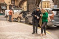 A pair of tourists look at the phones on the street near the powder tower in Prague