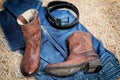 Leather cowboy boots leather belt and jeans on straw Royalty Free Stock Photo