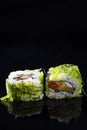 Pair of Traditional Sushi Rolls With Green Sea Algae Together on Black Reflective Surface Royalty Free Stock Photo