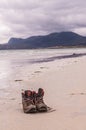 Pair of trekking boots on a remote beach with sea and mountains