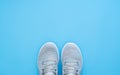 Pair of trendy sport sneakers on light blue background. Top view with copy space