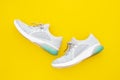 Pair of trendy sport sneakers on yellow background. Top view with copy space