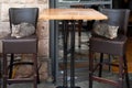 A pair of twin, grey, feral, Jerusalem street cats strike a symmetrical pose on a pair of identical bar stools Royalty Free Stock Photo