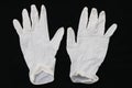 Pair of two medical white rubber gloves on black background.