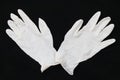 Pair of two medical white rubber gloves on black background.