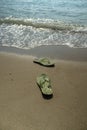 Pair, two of men`s beach slippers on the sand Royalty Free Stock Photo