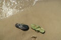 Pair, two of men`s beach slippers on the sand Royalty Free Stock Photo