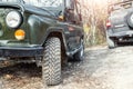 Pair of two old retro vintage 4x4 soviet suv vehicle on dirt gravel unpaved road in summer at sunset morning sun. Off Royalty Free Stock Photo