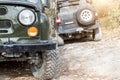Pair of two old retro vintage 4x4 soviet suv vehicle on dirt gravel unpaved road in summer at sunset morning sun. Off Royalty Free Stock Photo