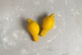 A pair of ugly lemons on a gray background.