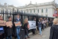 Crowd of University students seen at a peaceful protest, while holding protest signs.