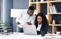 Pair up and get better results. a young businessman and businesswoman using a digital tablet and laptop in a modern Royalty Free Stock Photo