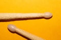 Pair of used drumsticks on yellow background