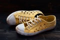 Pair of used old fashioned sneakers shoes on dark wooden surface Royalty Free Stock Photo