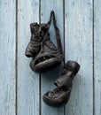 pair of very old leather black boxing gloves hanging on a nail Royalty Free Stock Photo