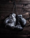 Pair of very old shabby black leather boxing gloves hanging on a Royalty Free Stock Photo