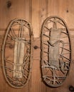 A pair of very old snowshoes hanging on a wooden wall