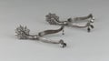 Pair of vintage rowel spurs on a white background