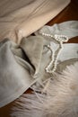 A pair of vintage stockings, a girdle, a feather, and pearls on a dressing table