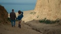 Pair walking down seacoast to empty beach. Happy couple going on ocean shore. Royalty Free Stock Photo