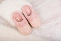 Pair of warm female slippers on white furry carpet Royalty Free Stock Photo
