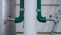 Pair of water taps in green plastic pipes on light background Royalty Free Stock Photo