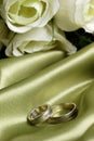 Pair of wedding bands on green satin Royalty Free Stock Photo