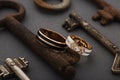 Pair of wedding enamel rings on gray background with vintage rusty keys Royalty Free Stock Photo