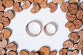 Pair wedding gold rings framed by wooden hearts on white background. Overhead shot Royalty Free Stock Photo