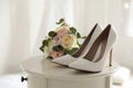 Pair of wedding high heel shoes and beautiful bouquet on white table, closeup Royalty Free Stock Photo